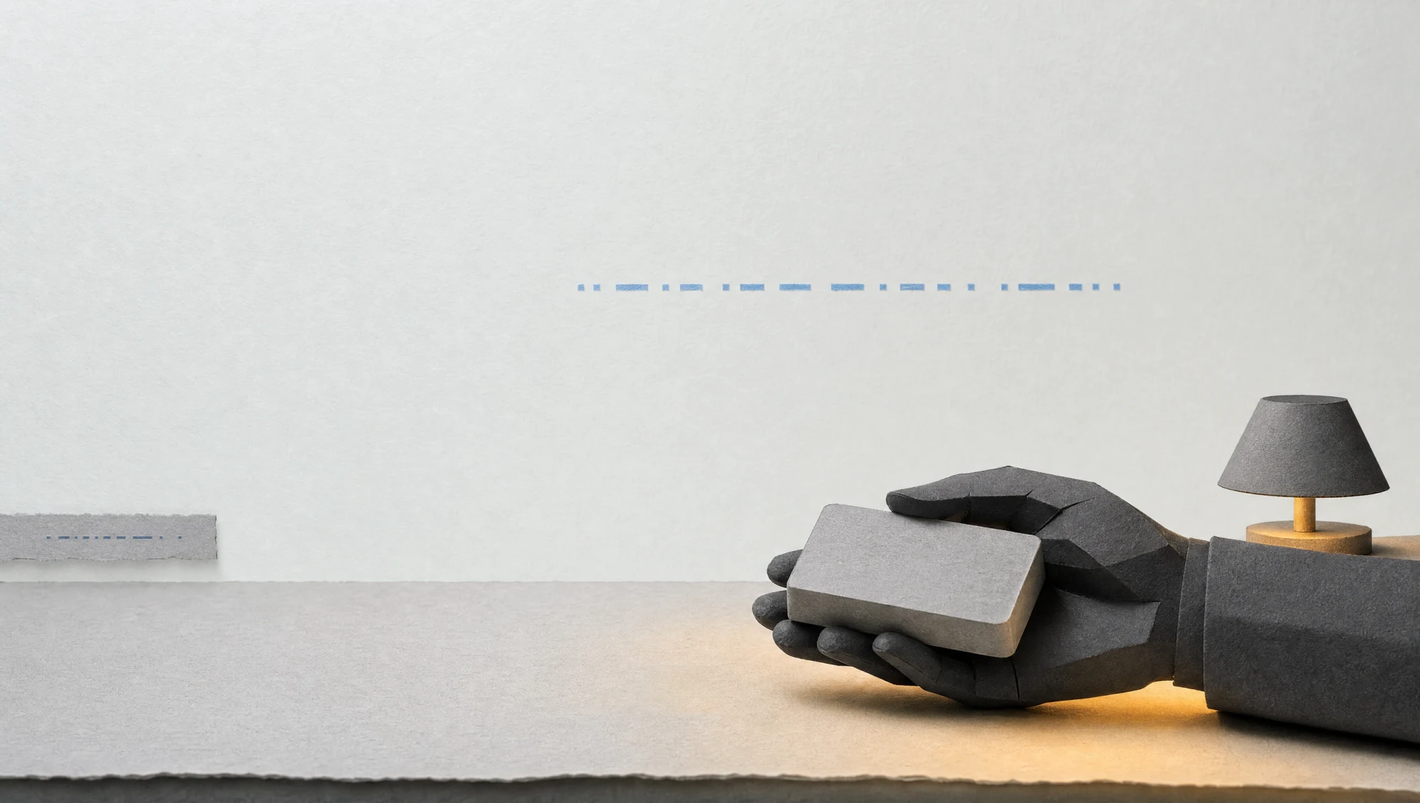 An original paper diorama: an anonymous graphite hand under a warm amber lamp holds a small plain gray block on a bare table, while the faintly glowing pale wall above still carries one line of unreadable marks; at the far left a small gray paper strip with the same marks, dimmer, enters the frame. The glowing wall is a symbolic stand-in for the ship's computer. The hand is a generic, low-detail hand with no likeness of any performer.